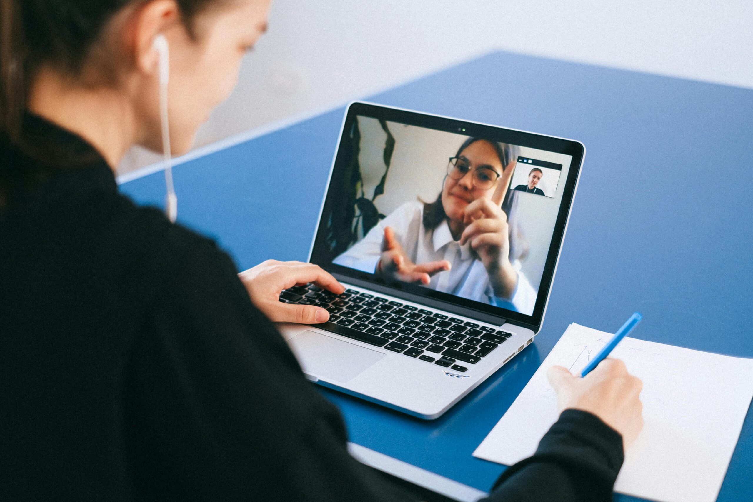 Two people in consultation over the phone and computer.