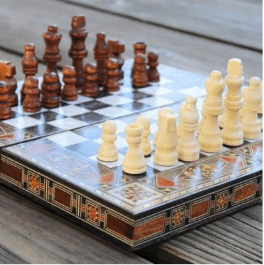 A handcrafted wooden board designed for both chess and backgammon, featuring intricate detailing.