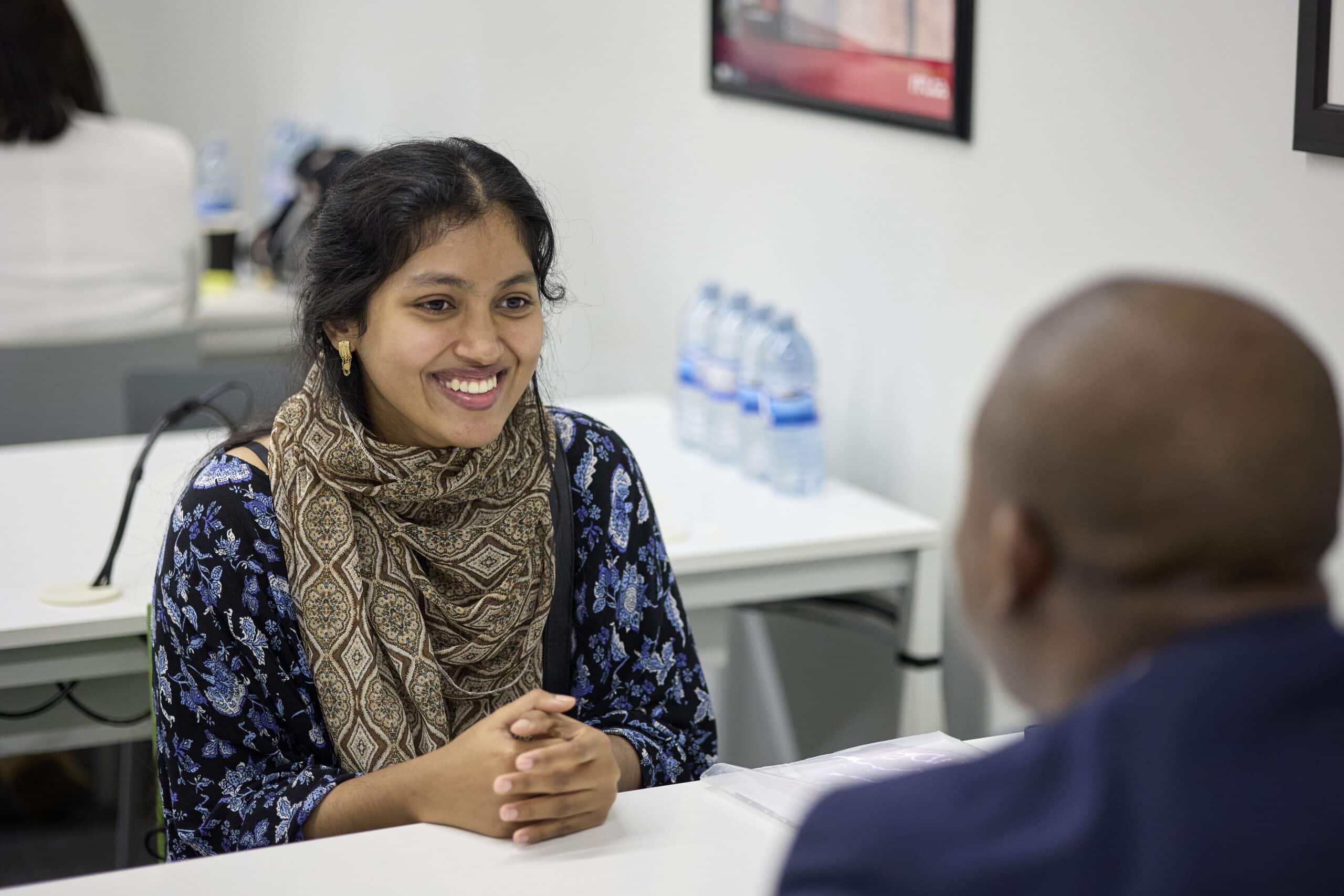 Woman in blue smiling during job interview
