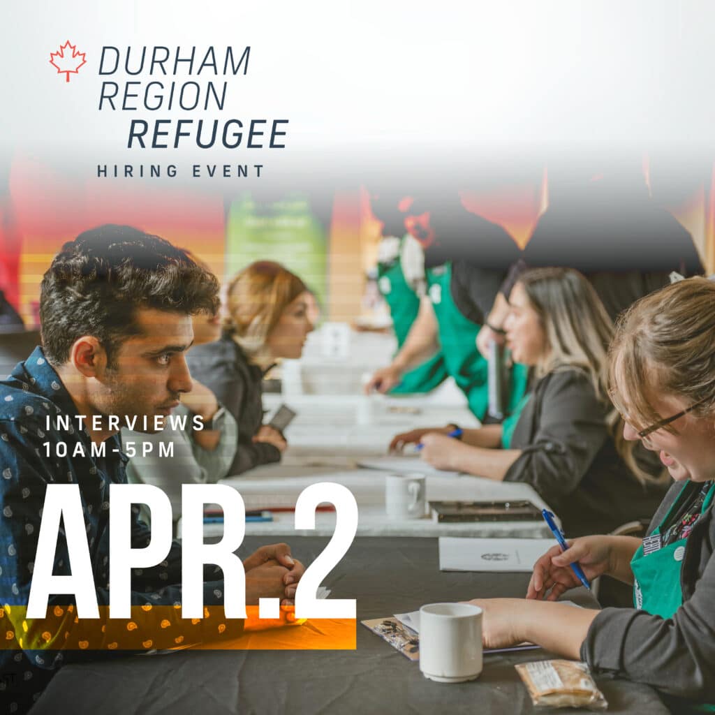 A refugee hiring event where job seekers are being interviewed by employers seated across tables. The image highlights a focused male candidate and recruiters taking notes. Text reads: "Durham Region Refugee Hiring Event – Interviews 10AM–5PM – Apr. 2".