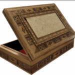 A rectangular wooden keepsake box featuring a complex mosaic pattern created by intricate wood inlay techniques and small pieces of iridescent white shell. The lid is slightly open, revealing a vibrant red velvet lining inside the box.